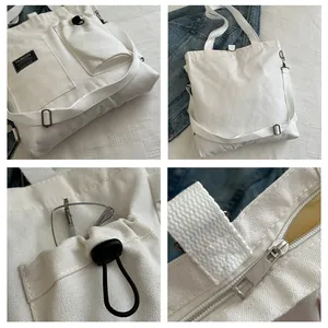 Detail view of cream canvas tote bag showing functional side pockets and adjustable strap