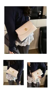 Detailansicht der cremefarbenen Ledertasche mit goldenem Ringverschluss und glatter Textur