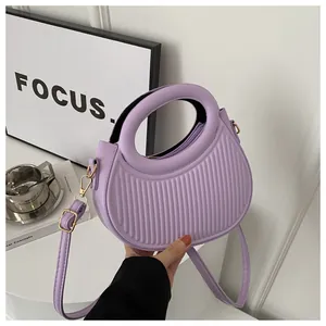 Close-up of purple PU leather handbag featuring vertical pleated texture and round handle