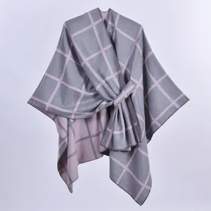Dettaglio dello scialle in maglia a quadri rosa e grigi con fibbia della cintura