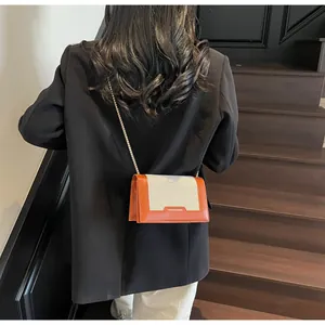 Detailaufnahme einer beige Leinwand und orangefarbenen Leder Umhängetasche an Model