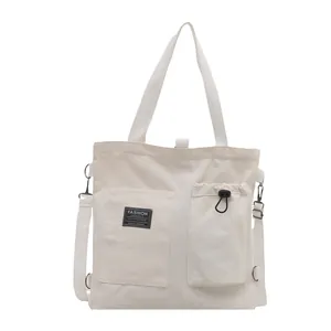 Minimalist cream canvas tote bag with multi-pocket design and adjustable shoulder strap