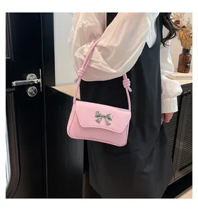 Dettaglio della borsa a spalla in pelle PU rosa con fiocco argento e cinturino annodato