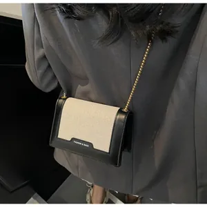 Detailansicht der Canvas-Leder-Umhängetasche mit goldener Kette an einem Model