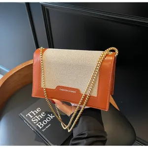 Detail der orangefarbenen Leder-Beige-Stoff-Umhängetasche mit goldener Kettenriemen