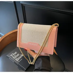 Detail der rosa Leder- und beigefarbenen Kettentasche mit goldener Metallkette