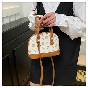 Detail einer Mini-Muschel-Tasche mit Monogrammmuster, Beige und Braun Kontrast-Leder