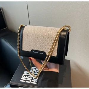 Detailaufnahme der modischen Umhängetasche aus Segeltuch mit Lederbesatz und goldener Kette
