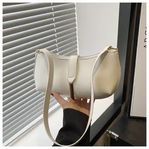 Detail of off-white leather underarm bag featuring a minimalist gold metal buckle design