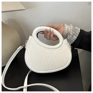 Detail of white pleated handbag with unique circular cutout handle and vertical stripes