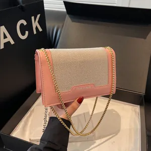 Schicke Umhängetasche aus rosa Leder und Webstoff mit goldener Kette für Damen