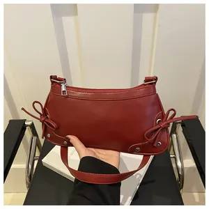 Détail du sac bandoulière en cuir PU bordeaux avec nœuds décoratifs et rivets argentés