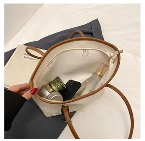 Interior view of the large white tote bag showing storage for phone and cosmetics
