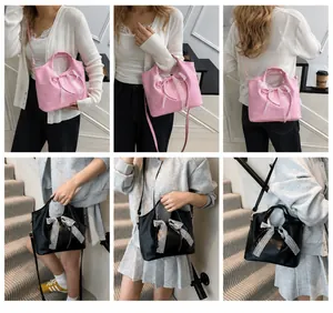 Detail view of large lace bow decoration on pink and black shoulder bucket bags