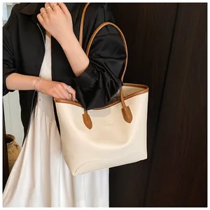 Close-up of cream white tote bag with pebble leather texture and brown handle details