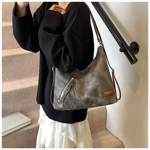 Detailed view of grey vintage canvas hobo bag with brown leather accents and zipper detail
