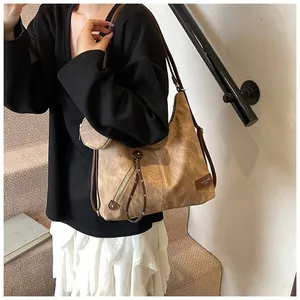 Detail view of large khaki tote bag with matte leather texture and small round coin purse