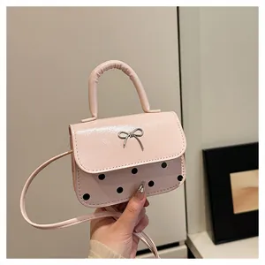 Detail der hellrosa Mini-Tasche mit schwarzen Punkten und silberner Metallschleife