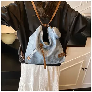 Detail of vintage washed blue backpack with leather patch and mini round coin purse