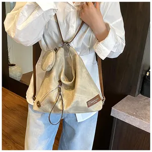 Detail of vintage beige canvas tote bag featuring adjustable strap and small coin purse