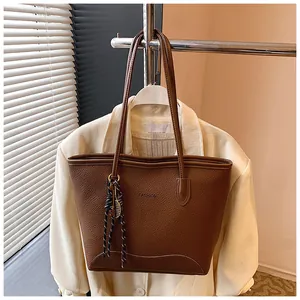 Close-up of brown litchi pattern tote bag with Fashion text and silk scarf detail