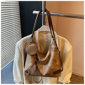Detail of vintage brown leather tote bag with tassel charm and detachable coin purse