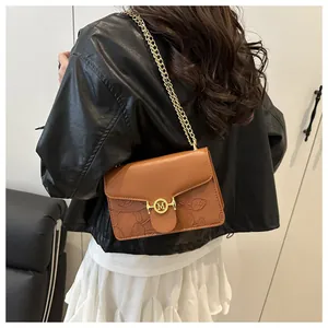Dettaglio borsa in pelle PU marrone con rilievi floreali e fibbia con logo M