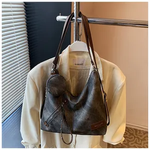Detailed view of large grey tote bag with brown leather handles and small coin purse