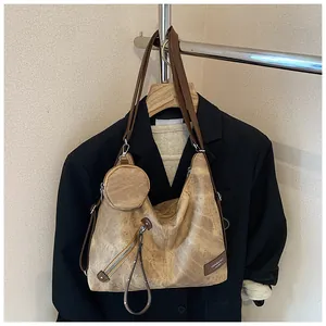Retro brown hobo bag with matching round coin purse shown on a black suit blazer
