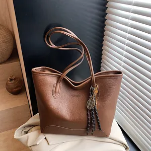 Vintage caramel brown tote bag with fashion embossing and tassel charm details