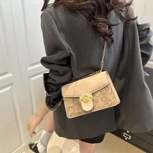 Elegante borsa a tracolla beige in ecopelle goffrata a fiori con fibbia metallica a M
