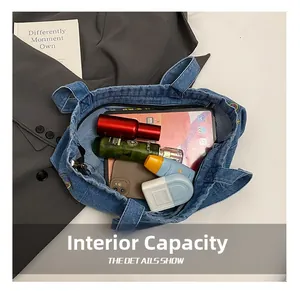 Internal capacity of denim tote bag showing storage for tablet, phone and cosmetics