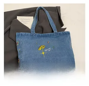 Close-up of vintage blue denim tote with yellow Groovy Trippy Heart embroidery and stars