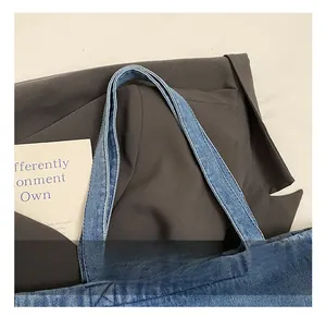 Detail of reinforced denim handles with double stitching on a vintage tote bag