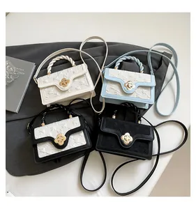 Detail of four colorful handbags showing braided handles and floral metal twist locks