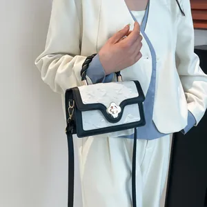 Women's chic black and white square bag with woven handle and clover metal clasp