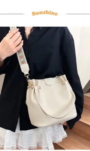 Detail of off-white bucket bag with textured leather and ethnic jacquard wide strap