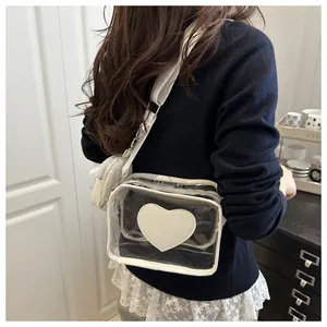 Dettaglio della borsa a tracolla in PVC trasparente con cuore bianco e piccolo borsellino
