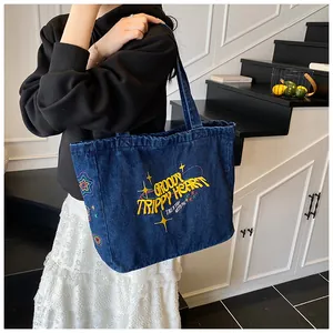 Close-up of retro denim tote bag featuring colorful groovy embroidery and star patterns
