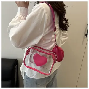 Detail of transparent PVC crossbody bag featuring pink heart patch and matching coin purse