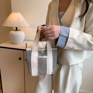 Minimalistische zwart-wit gestreepte geweven draagtas met canvas banden en zilveren knop