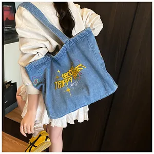 Close-up of blue denim tote bag featuring yellow Groovy Trippy Heart embroidery