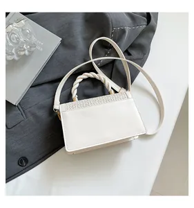 Top view of cream white crossbody bag with braided flap and twisted handle detail