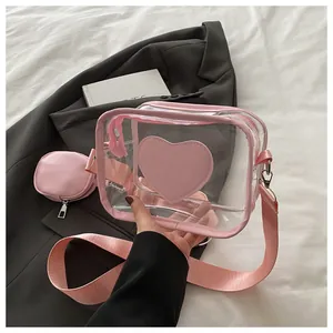Detail of pink transparent PVC crossbody bag featuring heart patch and round coin purse