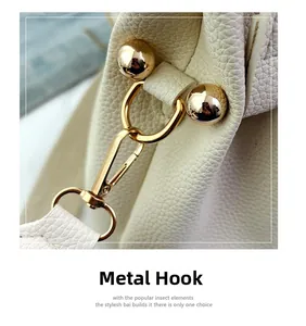 Macro shot of durable golden hardware hook and litchi texture on white leather bag
