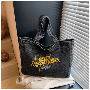 Macro shot of embroidered Groovy Trippy Heart text on retro washed denim tote bag