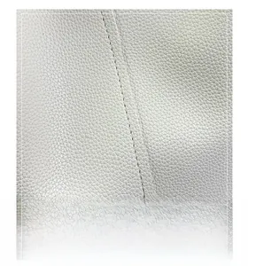Detailed macro view of high-quality white pebbled leather and precision double stitching