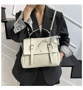 Dettaglio borsa vintage crema con fiocco in pizzo, ciondolo di perle e fibbia d'argento