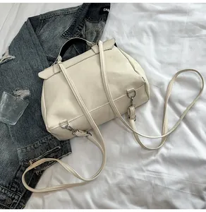Dettaglio borsa a mano bianco crema in pelle con tracolle e fibbie metalliche