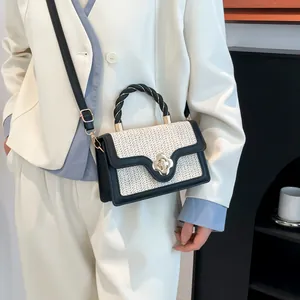 Minimalist beige woven crossbody bag with black trim and golden floral clasp for women